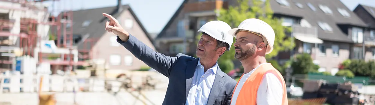 Besprechung eines Architekten und eines Bauleiters auf der Baustelle