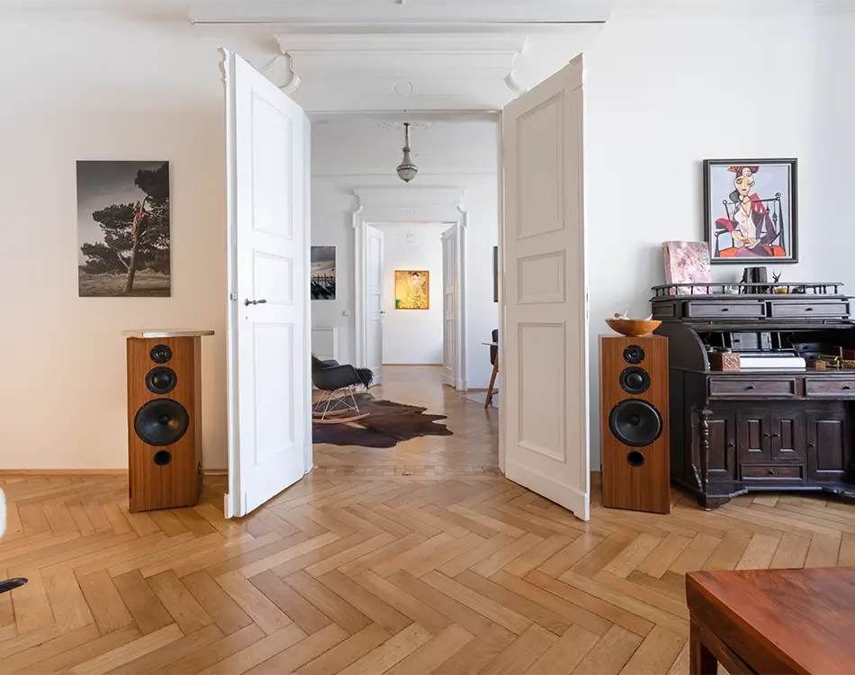 altbauwohnung mit fischgrat parkett und im zimmer steht ein klavier und musikboxen im rustikalen stil